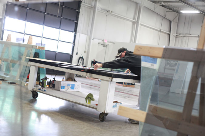 A photograph of an employee cutting glass